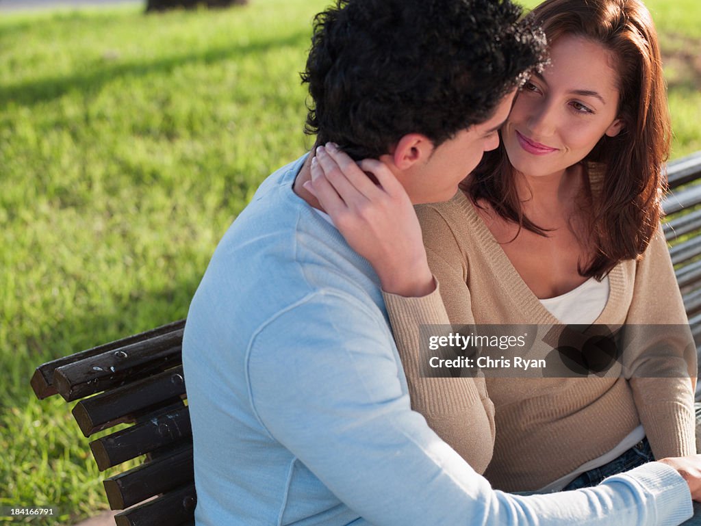 Young couple sitting on wooden bench 