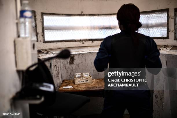 Prison warden monitors inmates taking a stroll in the courtyard of the Bordeaux-Gradignan jail in Gradignan on the outskirts of Bordeaux on December...