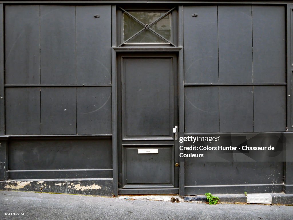 Close-up of the empty and black facade of a old closed shop in Paris, France.