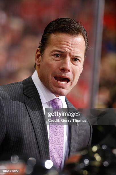 Assistant Coach Martin Gelinas of the Calgary Flames watches game action from the bench against the New Jersey Devils at Scotiabank Saddledome on...
