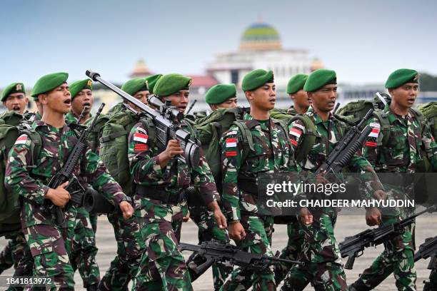 Indonesian soldiers take part in a ceremony before travelling to Papua for deployment in security operations, at Sultan Iskandar Muda Airforce base...