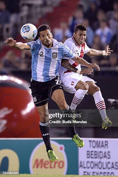 Ezequiel Garay of Argentina fights for the ball with Edwuin Gomez Gutierrez of Peru during a match between Argentina and Peru as part of the 17th...