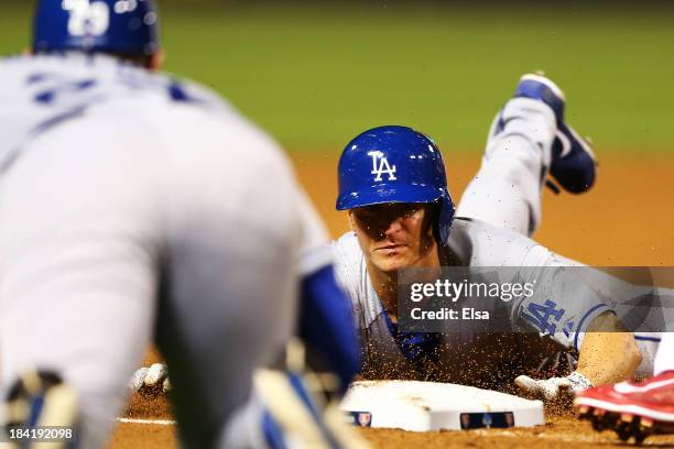 Mark Ellis of the Los Angeles Dodgers slides into third on a triple in the 10th inning against the St. Louis Cardinals during Game One of the...