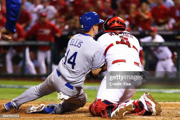 Mark Ellis of the Los Angeles Dodgers is out at home plate in the 10th inning against Yadier Molina of the St. Louis Cardinals during Game One of the...