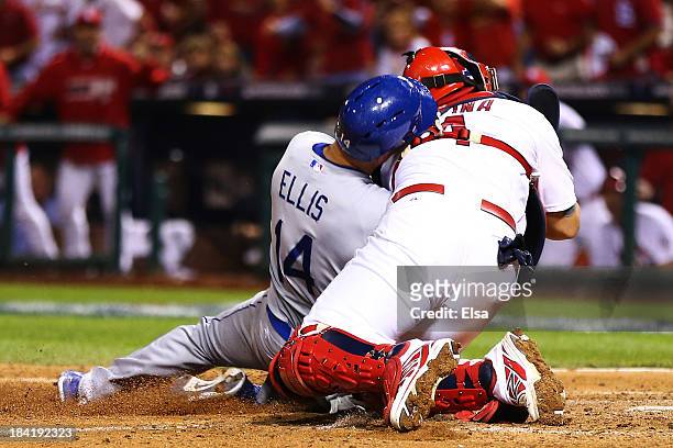 Mark Ellis of the Los Angeles Dodgers is out at home plate in the 10th inning against Yadier Molina of the St. Louis Cardinals during Game One of the...