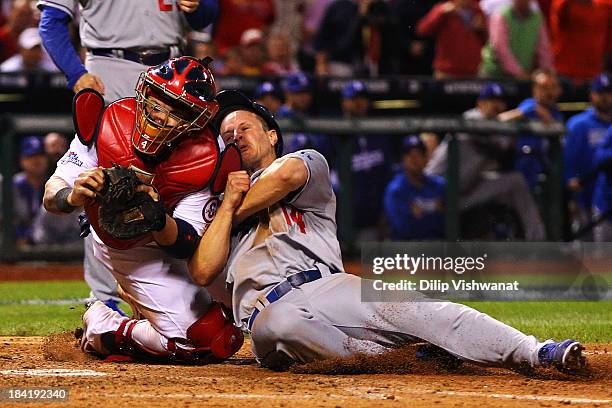 Mark Ellis of the Los Angeles Dodgers is out at home plate in the 10th inning against Yadier Molina of the St. Louis Cardinals during Game One of the...