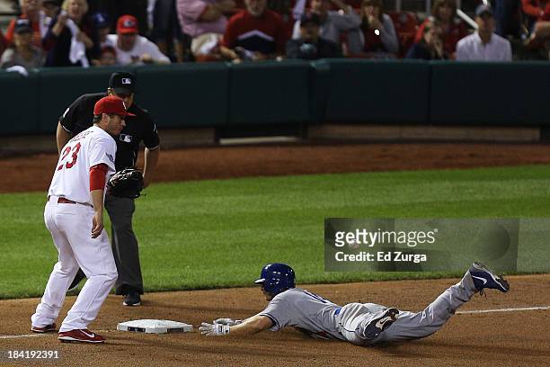 Mark Ellis of the Los Angeles Dodgers slides into third on a triple in the 10th inning against the St. Louis Cardinals during Game One of the...