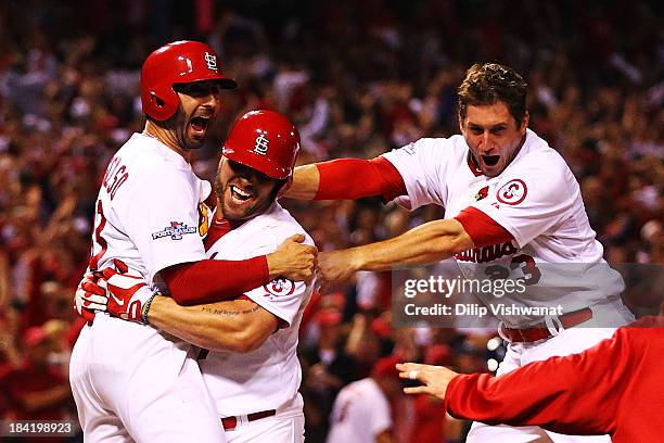 David Freese and Daniel Descalso and Matt Holliday of the St. Louis Cardinals celebrate their to 2 win over the Los Angeles Dodgers in Game One of...