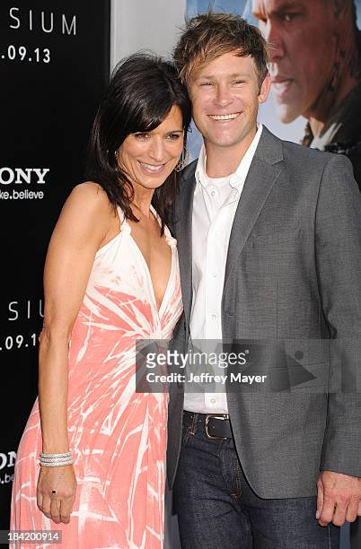 Actress Perrey Reeves and guest arrive at the Los Angeles premiere of 'Elysium' at Regency Village Theatre on August 7, 2013 in Westwood, California.