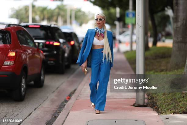 Denisa Palsha seen wearing white sunglasses, Louis Vuitton gold logo earrings, Louis Vuitton blue / pink / white colorful pattern silk scarf, white...