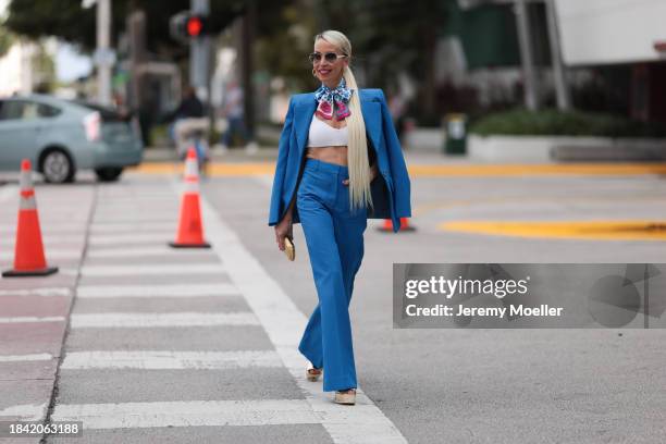 Denisa Palsha seen wearing white sunglasses, Louis Vuitton gold logo earrings, Louis Vuitton blue / pink / white colorful pattern silk scarf, white...