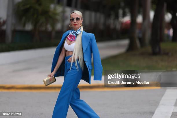 Denisa Palsha seen wearing white sunglasses, Louis Vuitton gold logo earrings, Louis Vuitton blue / pink / white colorful pattern silk scarf, white...