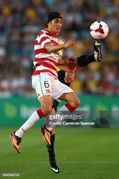 Jerome Polenz of the Wanderers contests the ball with Josh Rose of the Mariners during the round one A-League match between the Central Coast...