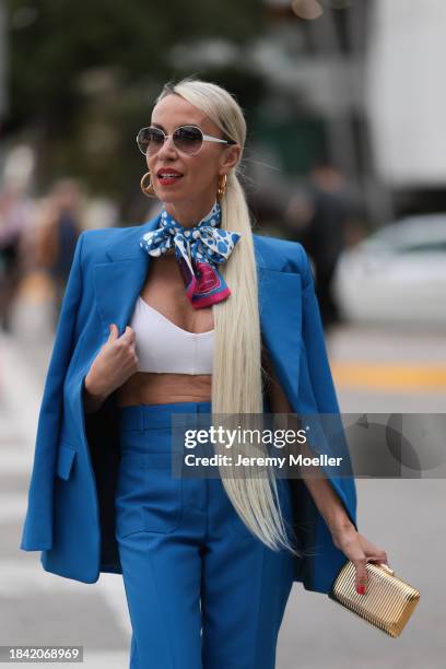 Denisa Palsha seen wearing white sunglasses, Louis Vuitton gold logo earrings, Louis Vuitton blue / pink / white colorful pattern silk scarf, white...