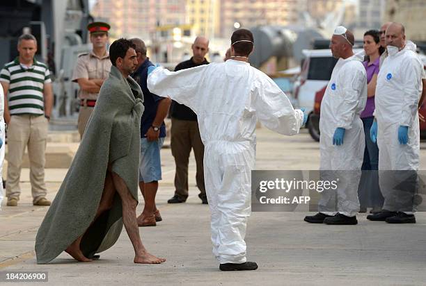 Migrant wrapped in a banket arrives at Hay Wharf in Valletta after being rescued by a patrol boat of the Armed forces of Malta on October 12 a day...