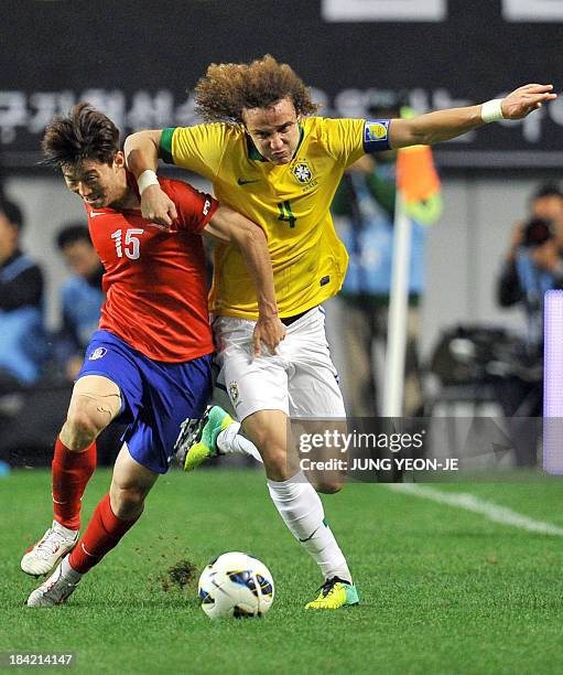 Brazilian defender David Luiz vies the ball against South Korean midfielder Kim Bo-Kyung during a friendly football match in Seoul on October 12,...