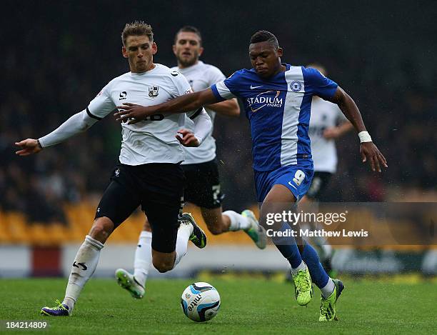 Daniel Jones of Port Vale and Britt Assombalonga of Peterborough United challenge for the ball during the Sky Bet League One match between Port Vale...