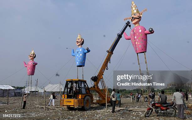 Organisers erecting effigy of demon king Ravana with the help of crane ahead of Dussehra festival on October 12, 2013 in Noida, India. The effigies...