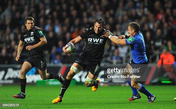 Ospreys player Joe Bearman breaks the tackle of Leinster fly half Jimmy Gopperth during the Heineken Cup Pool1 game between Ospreys and Leinster at...