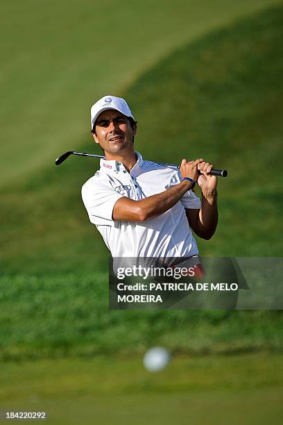 Chilean golfer Felipe Aguilar plays a shot from a bunker to chip the ball onto the 15th hole during third round of the Portugal Masters golf...