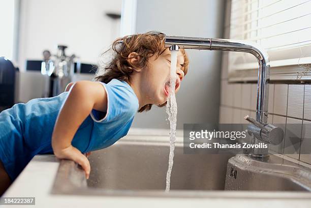 small boy drinking water - water photos et images de collection