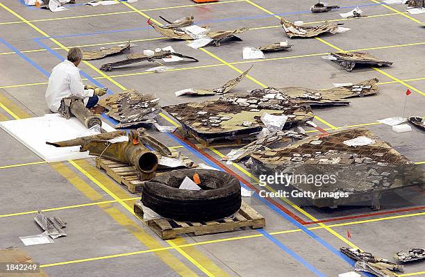 In this NASA handout photo, a NASA crash investigator examines debris from the Space Shuttle Columbia inside a hangar March 11, 2003 at the Kennedy...