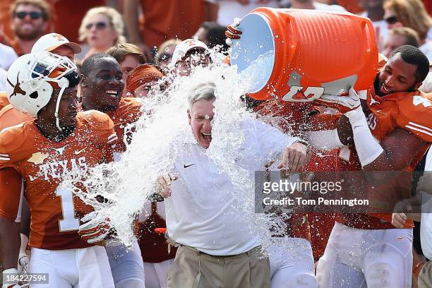 Head coach Mack Brown of the Texas Longhorns has a cooler of ice water dumped on him by his team after the Longhorns beat the Oklahoma Sooners 36-20...