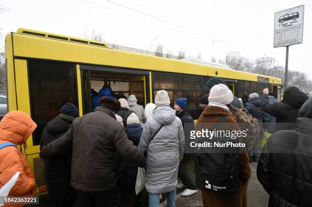 Passengers are getting on a bus that is operating between the closed metro stations of the Blue Line in Kyiv, Ukraine, on December 11, 2023. Train...