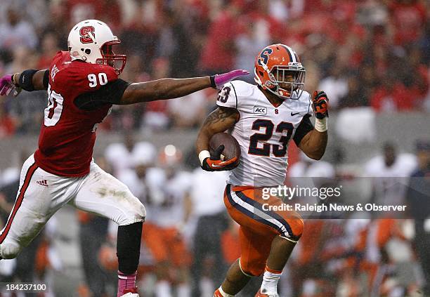 Syracuse running back Prince-Tyson Gulley breaks off a big gain as North Carolina State defensive end Mike Rose closes in during the second half on...