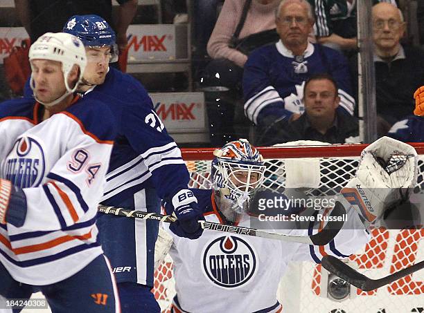 Edmonton Oilers goalie Devan Dubnyk makes a glove cave in front of James van Riemsdyk and Edmonton Oilers left wing Ryan Smyth as the Toronto Maple...
