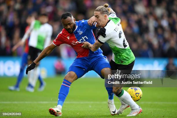 Jordan Ayew of Crystal Palace is challenged by Kostas Tsimikas of Liverpool during the Premier League match between Crystal Palace and Liverpool FC...