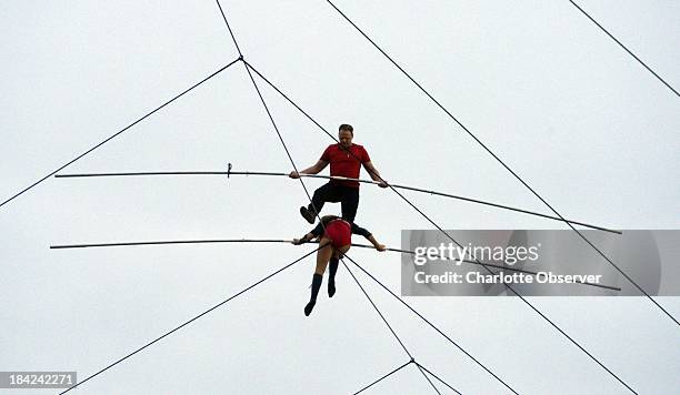 Nik Wallenda, top, walks the tightrope above Charlotte Motor Speedway on Saturday, October 12 with his sister, Lijana, 140 feet above pit road during...