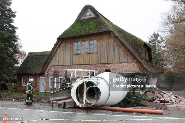 December 2023, Schleswig-Holstein, Blomesche Wildnis: Emergency services stand next to a concrete mixer that has crashed into a house. A multi-axle...