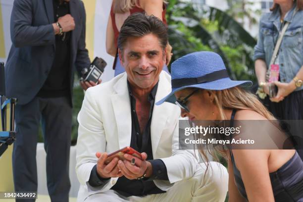 Actor/author John Stamos interacts with a fan during the Tribeca Storytellers: John Stamos at the Tribeca Music Lounge during Art Basel Miami Beach...