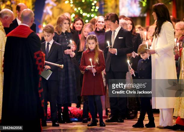 Princess Charlotte of Wales holds a candle as she leaves with her family at The "Together At Christmas" Carol Service at Westminster Abbey on...