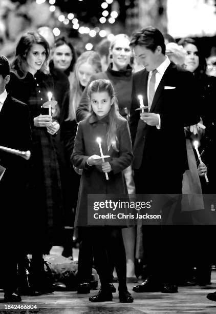 Princess Charlotte of Wales holds a candle as she leaves with her family at The "Together At Christmas" Carol Service at Westminster Abbey on...