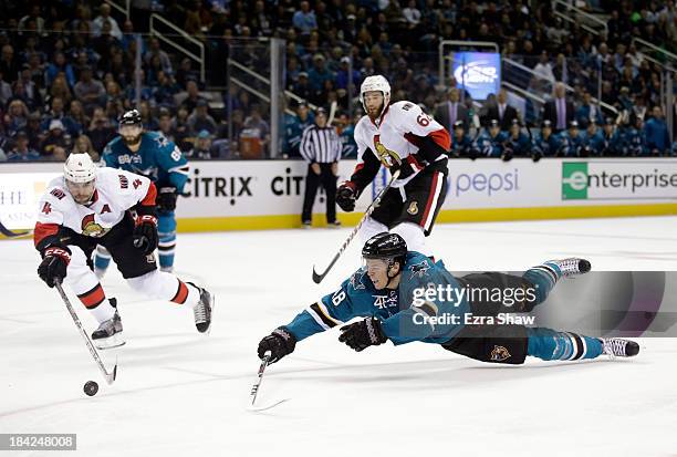 Tomas Hertl of the San Jose Sharks and Chris Phillips of the Ottawa Senators go for the puck at SAP Center on October 12, 2013 in San Jose,...