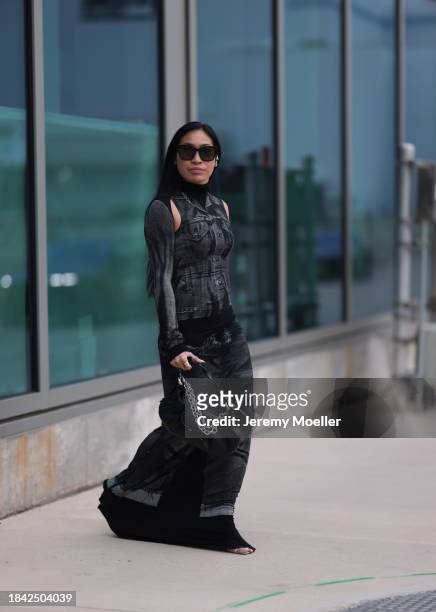 Miki Sui Cheung seen wearing Dior black sunglasses, Saint Laurent silver earrings, Jean Paul Gaultier black faded denim print pattern cut-outs long...