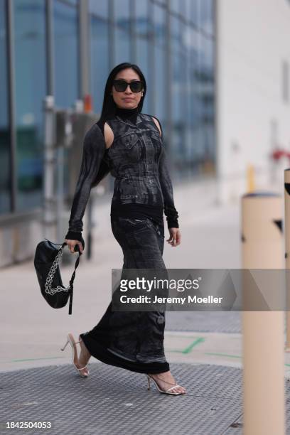 Miki Sui Cheung seen wearing Dior black sunglasses, Saint Laurent silver earrings, Jean Paul Gaultier black faded denim print pattern cut-outs long...