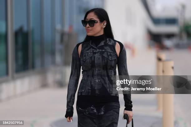 Miki Sui Cheung seen wearing Dior black sunglasses, Saint Laurent silver earrings, Jean Paul Gaultier black faded denim print pattern cut-outs long...