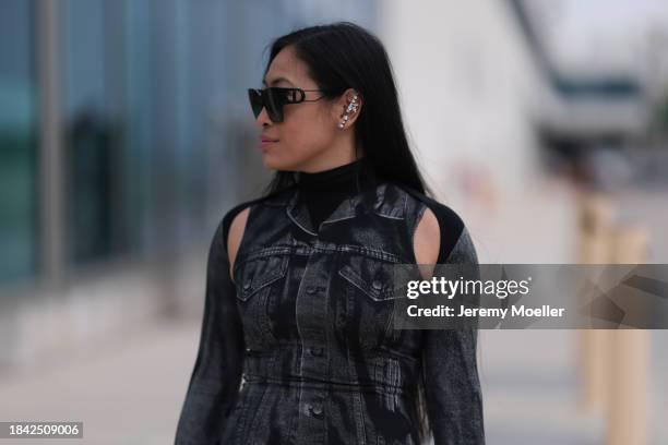 Miki Sui Cheung seen wearing Dior black sunglasses, Saint Laurent silver earrings, Jean Paul Gaultier black faded denim print pattern cut-outs long...