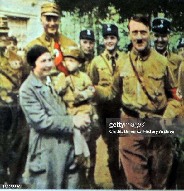 Hitler greets a German Nazi mother with child dressed in Nazi uniform circa 1932-33