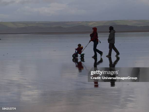 Young family at the beach in winter, UK.