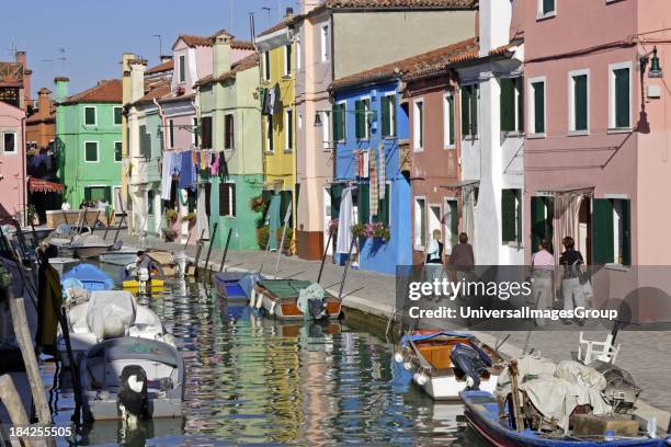 Italy Veneto Venice Burano brightly painted houses reflected in canals on this beautiful island in the Venice lagoon.