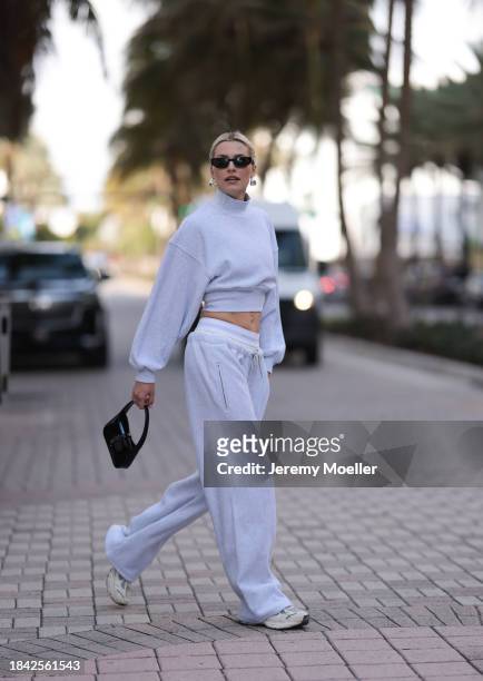 Lena Gercke seen wearing Saint Laurent black sunglasses, silver statement necklace, Alexander Wang light grey high neck cotton cropped jumper /...
