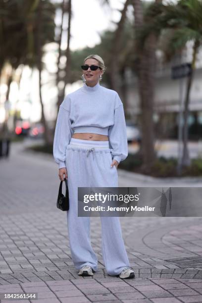 Lena Gercke seen wearing Saint Laurent black sunglasses, silver statement necklace, Alexander Wang light grey high neck cotton cropped jumper /...