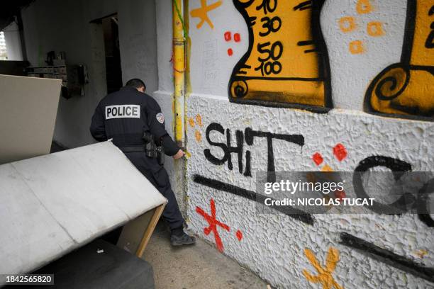 Police officer from the BST 14 Brigade, specialised in drug trafficking, searches for hidden drugs at a known dealing point in Les Rosiers housing...