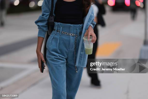 Paris Solati seen wearing black cotton tanktop, blue corduroy two-piece / blue corduroy shirt jacket, matching blue corduroy long pants, silver chain...