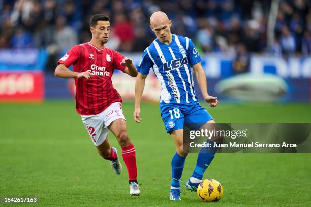 Jon Guridi of Deportivo Alaves duels for the ball with Enzo Loiodice of UD Las Palmas during the LaLiga EA Sports match between Deportivo Alaves and...
