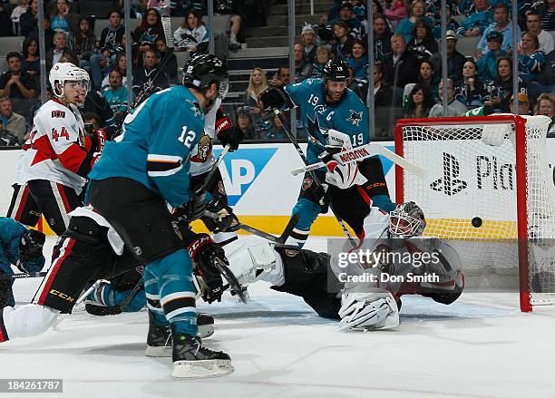 Joe Thornton of the San Jose Sharks watches as Patrick Marleau scores a goal against Robin Lehner of the Ottawa Senators during an NHL game on...